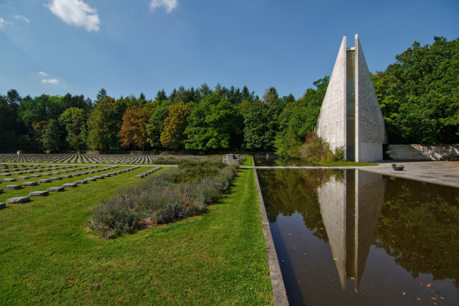 Pyramid-shaped memorial hall, reflecting pool and grave rows at Tischlerstraße War Cemetery